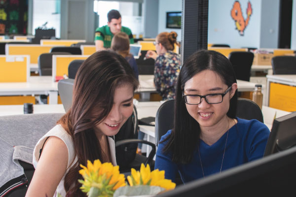 two hr managers conducting background checks for employment on a computer