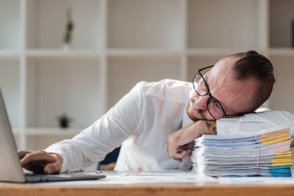 Man stressed at work over paperwork