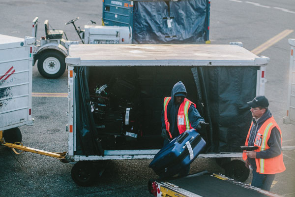 Employees loading cargo on transport vehicles at the airport