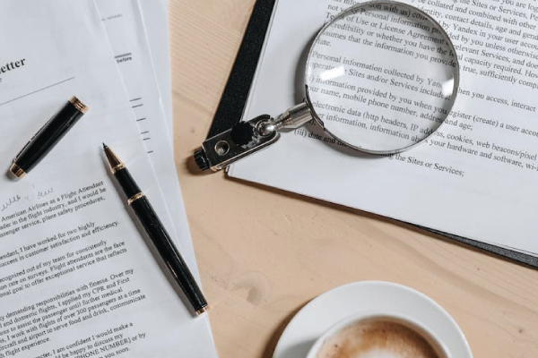 Paperwork and Magnifying Glass