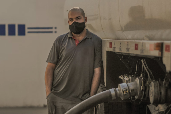 Trucker in a mask refueling
